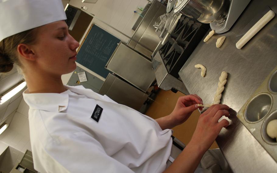 Pvt. Kayle Witzman, an Army food service specialist, prepares hot rolls at Fort Lee, Va. 
