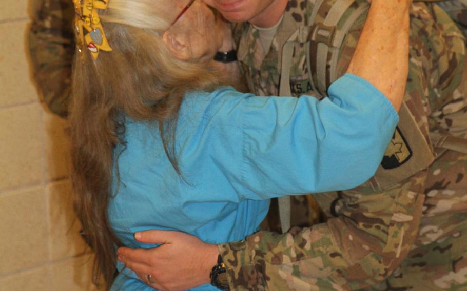 Capt. Edward Boncek receives a hug from Elizabeth Laird, affectionately known as "The Hug Lady," prior to boarding his flight to Afghanistan, July 11, 2013 at Fort Hood's Robert Gray Army Airfield. Soldiers asking the Defense Department and Fort Hood through a petition to rename in her honor the terminal at the airfield. 