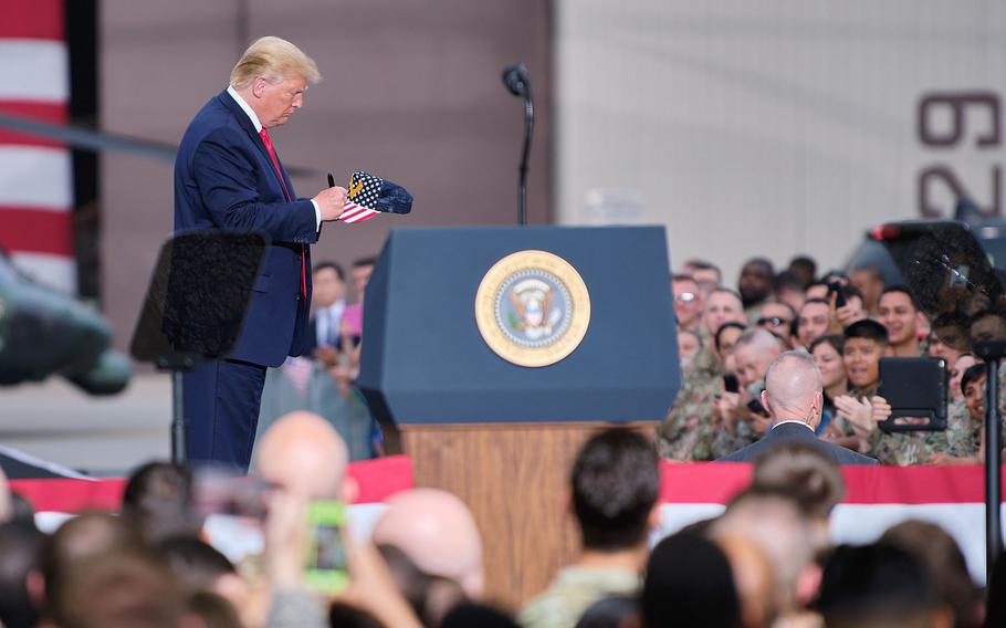 President Donald Trump autographs a servicemember's hat following his speech to servicemembers and families on Osan Air Base, South Korea, Sunday, June 30, 2019.
