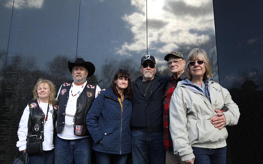 The families of soldiers who died on Flying Tiger Line Flight 739 pose in front of the Vietnam Veteran Memorial for a group photo. From right: Donna Ellis Cornell, daughter of Sgt. 1st Class Melvin Hatt, Clifton Sargent, brother of Spc. 4 Donald Sargent, Tommy Myers, son of Sgt. 1st Class Raymond Myers, Kimberly Steinman-Elmquist, daughter of Sgt. John Karibo, and Robert Rogers, a Vietnam Veteran with his fiancé Constance Austring.  