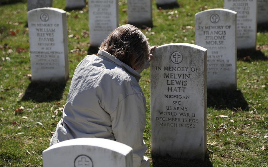Donna Ellis Cornell, daughter of Sgt. 1st Class Melvin Hatt, kneels before a headstone in Arlington National Cemetery that was placed in memory of her father, March 17, 2019. She learned just the night before that her grandmother had requested the headstone. 