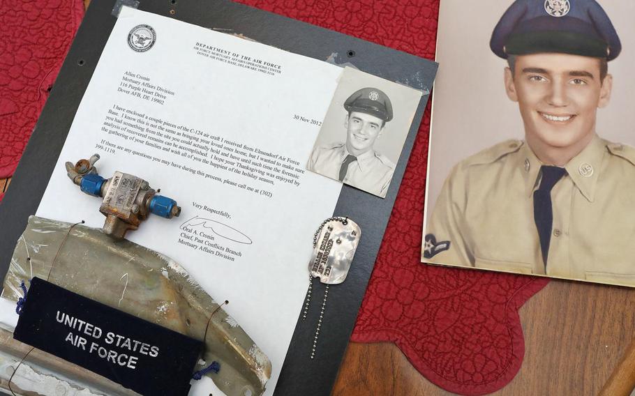 A photo of deceased U.S. Air Force Airman 2nd Class Edward J. Miller, who died in a plane crash in 1952 in Alaska, is displayed with a single dog tag, debris from the plane crash and a letter telling the family that these items were recovered from the crash.
