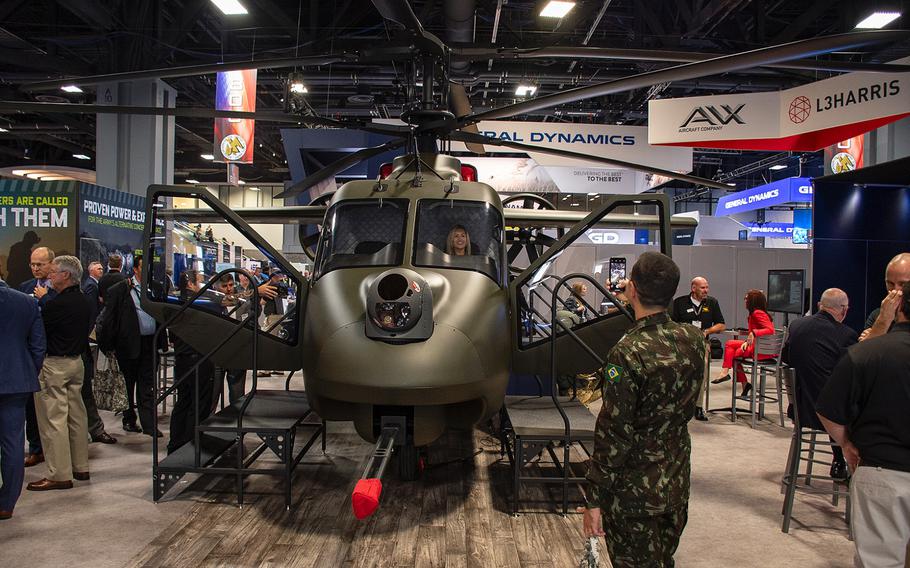 A woman has her picture taken while sitting in the cockpit of a prototype compound helicopter at the 2019 AUSA convention in Washington, D.C., on Tuesday, Oct. 15, 2019. The aircraft designed by AVX Aircraft Company and L3 Harris Technologies features dual coaxial rotors on top and two propellers in the rear.
