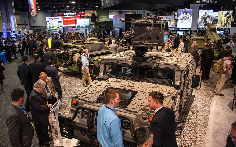 An assortment of ground vehicles draw crowds in a portion of an exhibition hall during the annual AUSA convention in Washington, D.C., on Tuesday, Oct. 15, 2019.