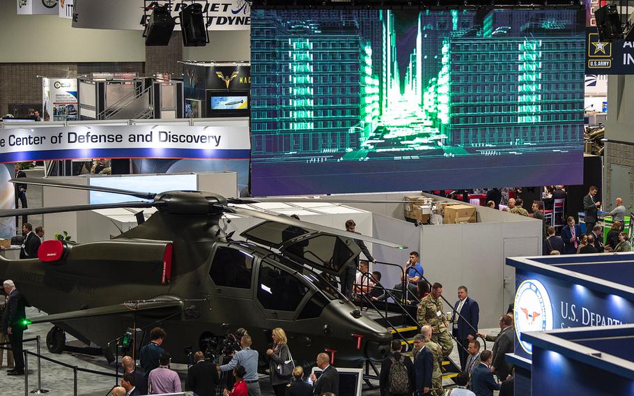 An illustrated video of an urban landscape through which a Bell 360 Invictus attack helicoper would be capable of flying plays on a screen above a static display of the proposed aircraft at the 2019 AUSA convention in Washington, D.C., on Tuesday, Oct. 15, 2019. The relatively small and sleek frame was designed to fit the Army's bid for a Future Attack Reconnaissance Aircraft.