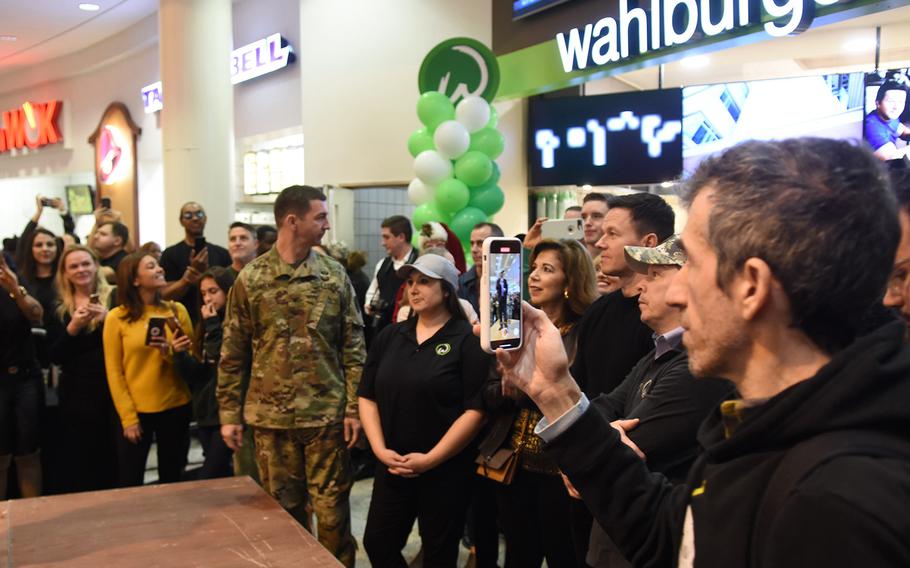 Actor Mark Wahlberg and his brother, Paul, a chef, stand in the middle of a large crowd in front of their fast-casual burger joint, Wahlburgers, set to open in early January at Ramstein Air Base, Germany. The brothers visited with service members on Sunday, Dec. 15, 2019.
