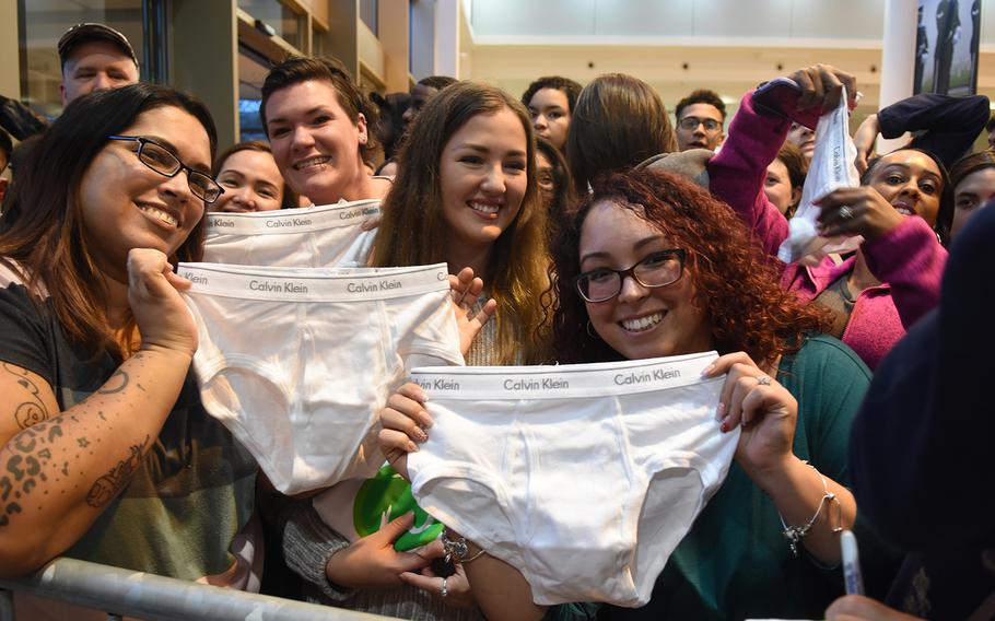 Military spouses Kristy Valentin, left, and Jennifer Spitznogle, right, hold up white Calvin Klein underwear they were hoping to get actor Mark Wahlberg to sign during his visit Sunday, Dec. 15, 2019, at Ramstein Air Base, Germany. Wahlberg famously modeled the underwear in his youth.
