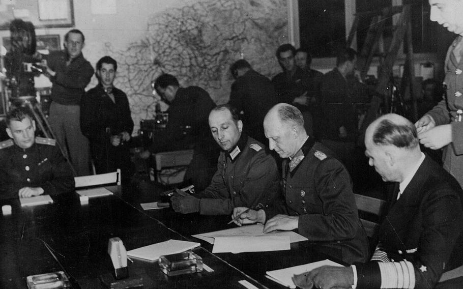 Col. Gen. Gustaf Jodl, German chief of staff to Adm. Karl Doenitz, reads the document of unconditional surrender of Germany to the Allies, which he is about to sign at 2:42 a.m. May 7, 1945, in the war room at Forward Headquarters of Supreme Headquarters Allied Expeditionary Forces at Reims, France. Under the instrument of surrender all German armed forces were bound to lay down their arms on all fronts. On Jodl's left is Adm. Hans-Georg von Friedeburg of the German navy, and on his right is Maj. Wilhelm Oxenius of the German general staff. Standing behind von Friedeburg is British Maj. Gen. K.W.D. Strong of the staff of Supreme Headquarters Allied Expeditionary Force. At the far left is Col. Ivan Zenkovitch, aide to Major General of Artillery Ican Susloparoff, who signed the document of surrender on behalf of the Soviet High Command.
