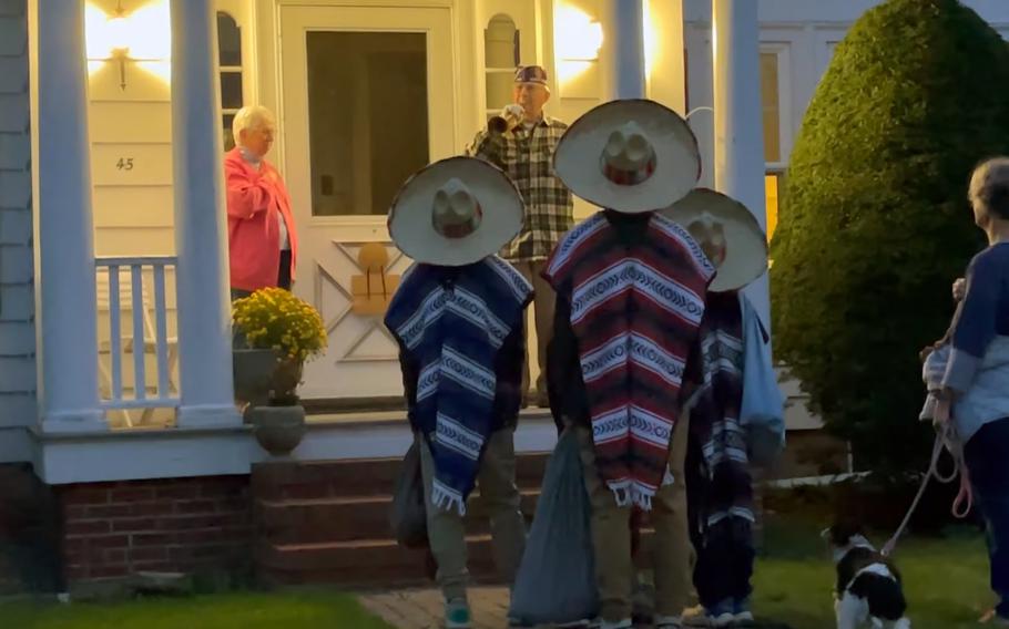 WWII veteran George Sherwood, shown here in a screenshot of a video shared to social media, sounds taps for trick-or-treaters on Oct. 31, 2021 at his home in Dover, N.H.