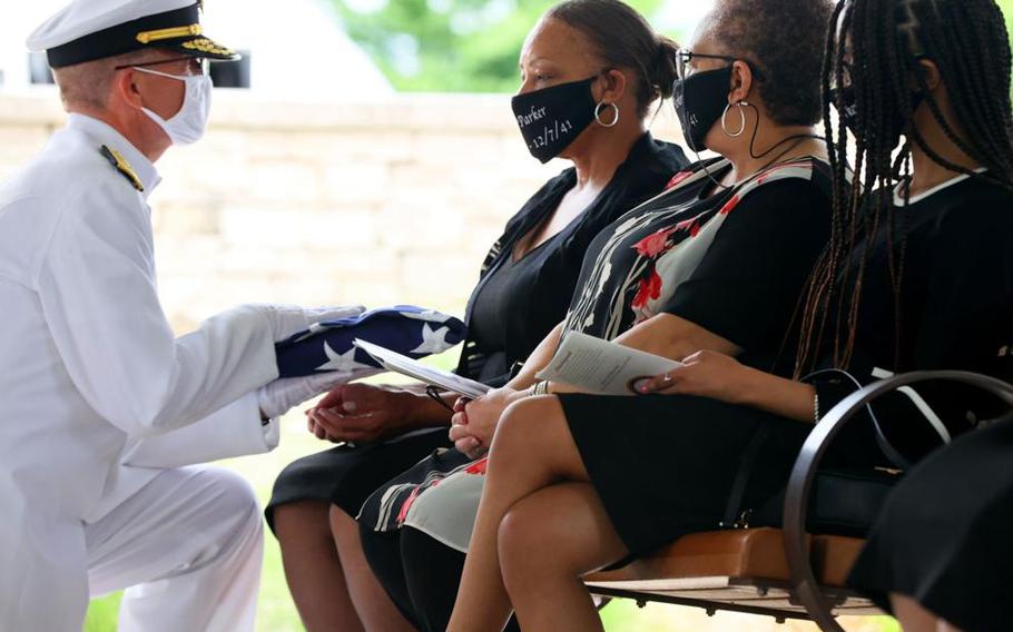 Angela Curtis, center, is presented with an American flag by Rear Adm. Eric Peterson of the U.S. Navy on Tuesday, June 8, 2021, during the funeral with full military honors for her uncle, Mess Attendant 3rd Class Isaac Parker, 17, nearly 80 years after his death on board the USS Oklahoma during the surprise attack at the Pearl Harbor naval base in 1941. Parker’s unidentified remains had been buried as an ‘unknown’ at the National Memorial Cemetery of the Pacific in Honolulu since the 1940s. They were recently identified by DNA, dental and anthropological means and returned to his family, now in St. Louis and buried at Jefferson Barracks National Cemetery. 
