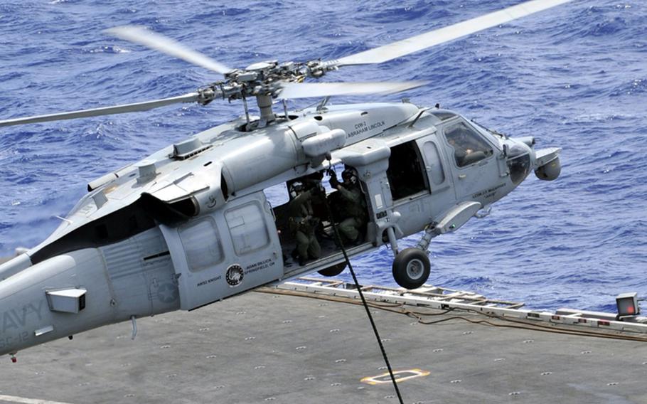 Sailors repel from an MH-60S Seahawk helicopter onto the flight deck of the aircraft carrier USS Abraham Lincoln in 2012. 
