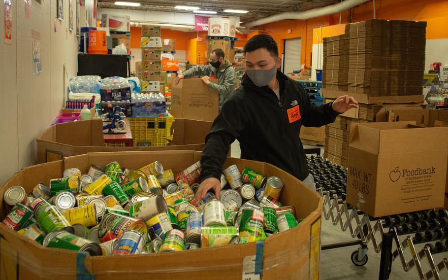 U.S. Navy Retail Service Specialist 3rd Class Anjo Balanza puts donated food items into boxes at the Foodbank of Southeastern Virginia and the Eastern Shore, in Norfolk, Virginia, April 1, 2021. 