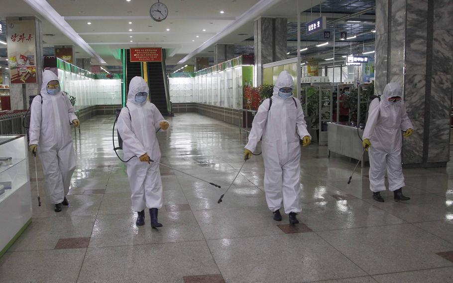 In this Dec. 28, 2020, file photo, staff of the Pyongyang Department Store No. 1 disinfect the store to help curb the spread of the coronavirus before it opens in Pyongyang, North Korea. 