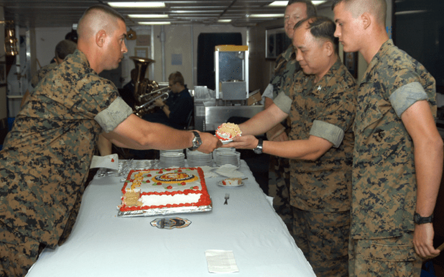 Col. Enrico DeGuzman, center right, is honored as the senior Marine at a cake-cutting ceremony in honor of the U.S. Marine Corps’ 229th birthday aboard the USS Blue Ridge, the command ship of the Seventh Fleet, in 2004 