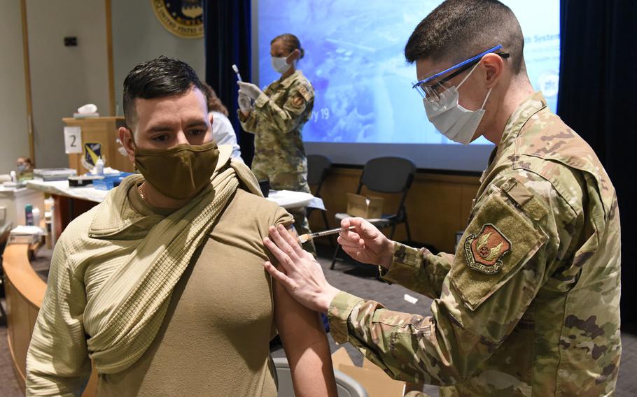 U.S. Army Sgt. 1st Class Joel Crespo a medic with the Lansing, Michigan Military Entrance Processing Station, receives the COVID-19 vaccine from Senior Airman Kody Phillips, a medical technician with the 88th Medical Group at Wright-Patterson Air Force Base, Ohio on Jan. 19, 2021. 