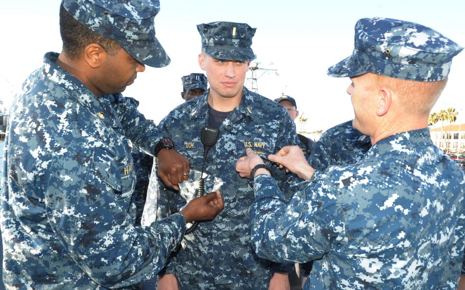 A sailor receives his surface warfare officer pin during a ceremony aboard the littoral combat ship USS Freedom on Jan. 15, 2014. 