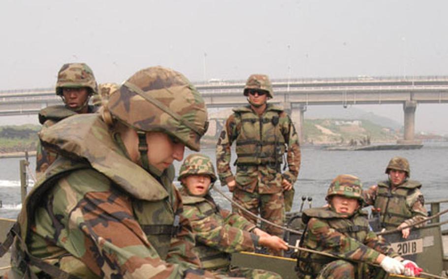 Cadet Katie Fidler helps U.S. and South Korean soldiers assemble a floating bridge raft on the Han River on June 9, 2004
(pnw# 49p ml)