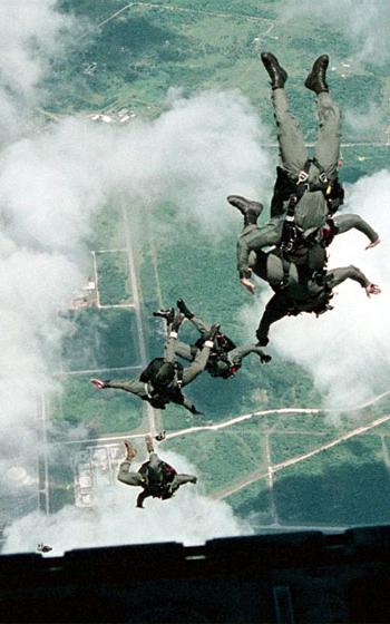 During certification training, members of Explosive Ordnance Disposal Mobile Unit Five and Naval Special Warfare Unit One perform a static line jump from a U.S. Air Force C-130 Hercules over Andersen Air Force Base in Guam.