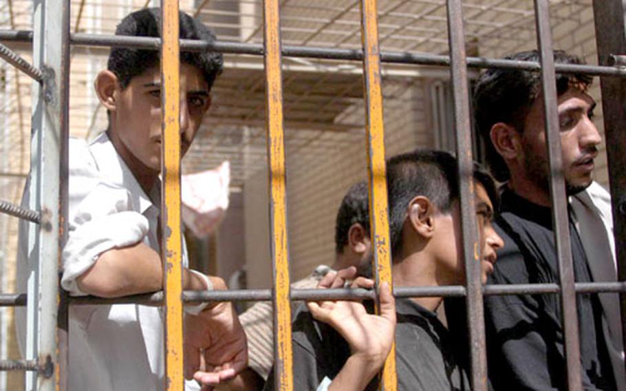 Prisoners wait Tuesday in Karbala jail in Iraq. The jail serves as a temporary holding area and currently the prison until one is built. U.S. Army military police and Iraqi police operate the jail.