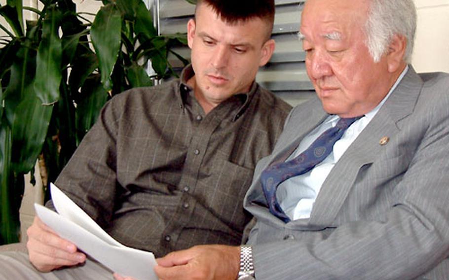 Marine Maj. Michael Brown and his attorney, Toshimitsu Takaesu, read a letter Brown presented to the U.S. Consulate on Okinawa requesting assistance from Ambassador Howard Baker concerning his ongoing trial on a charge of attempted rape. Brown was indicted Dec. 19, 2002; his trial is to resume Jan. 15.