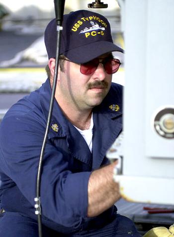 Navy Chief Petty Officer Greg Tillery of Jackson County, Ky., prepares a Mark 38 25mm machine gun aboard the USS Typhoon.