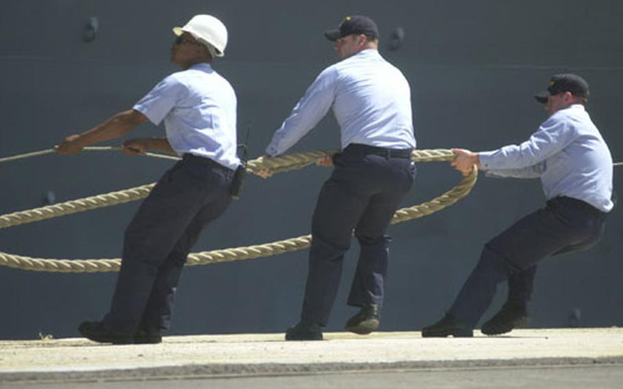 Sailors pull the lines to help moor the amphibious assault ship USS Wasp at Naval Station Rota, Spain, on Tuesday.