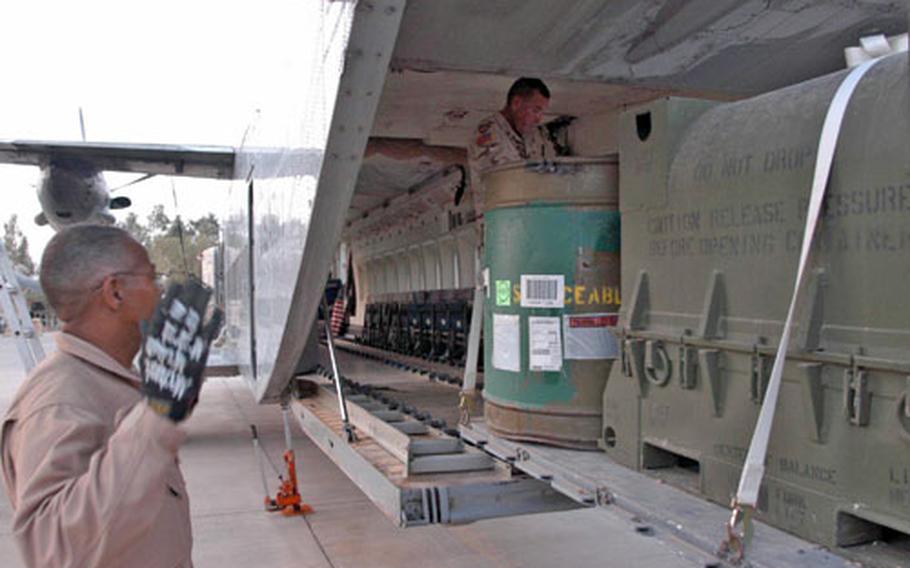 Cleveland Joyner, left, directs a forklift to deliver cargo in a C-23 Sherpa as Staff Sgt. Rudy Aleman readies the load.