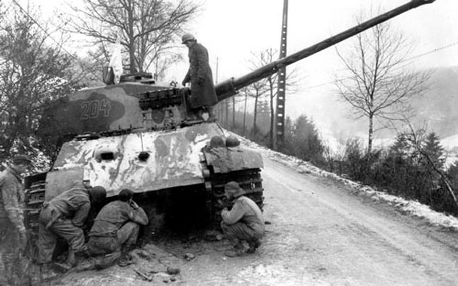U.S. soldiers inspect a German tank that was abandoned after it ran out of fuel in eastern Belgium and its crew surrendered. The tank had been on its way to reinforce Nazi troops during the Battle of the Bulge.
