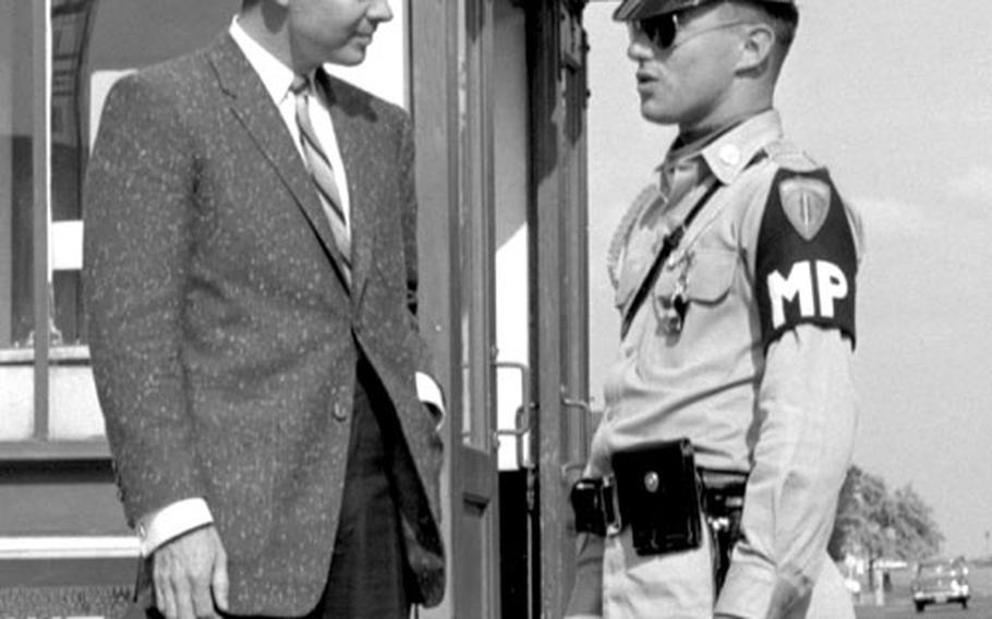 Audie Murphy talks with an MP at the gate at Würzburg.