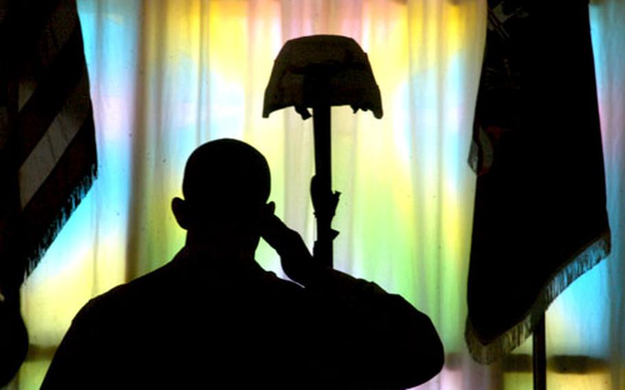 A soldier is silhouetted in front of the windows of Kandahar, Afghanistan's Fraise Chapel.