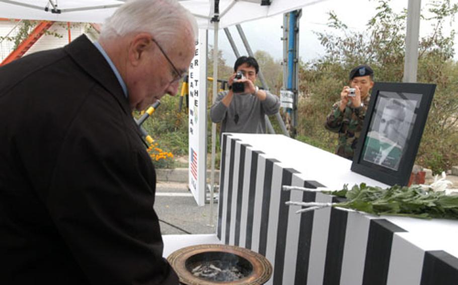 James Livingston lights incense during a ceremony dedicating a bridge in South Korea to his brother, 2nd Lt. Thomas W. Livingston Jr.