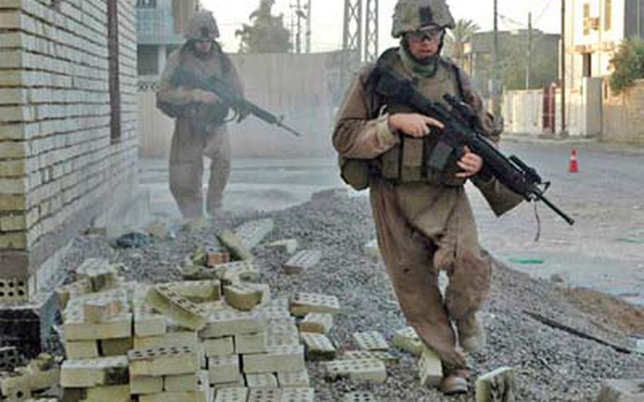 Marines from 1st Platoon, Company C, 1st Battalion, 25th Marine Regiment dash for cover in Fallujah on Wednesday after a sniper began firing into the street.