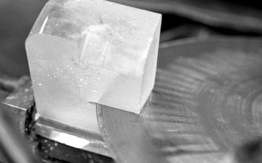 A diamond-enforced blade cuts into a block of glass.