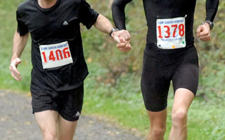 Neil Hersey, left, and Benjamin Martinelli run the final yards of the Frankenstein Castle Run hand-in-hand, with Martinelli narrowly winning the 13-kilometer race. Besides finishing second, Hersey was the top finisher in his age class.