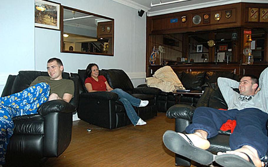 From right, Cpl. Garett Jaco, 23, Jackson, Miss., Sgt. Steven Barker, 22, Richmond, Va., and Cpl. Jessica Davila, 20, Waco, Texas, relax while off-duty in the living room of the Marine Corps living quarters not far from the U.S. Embassy in London.