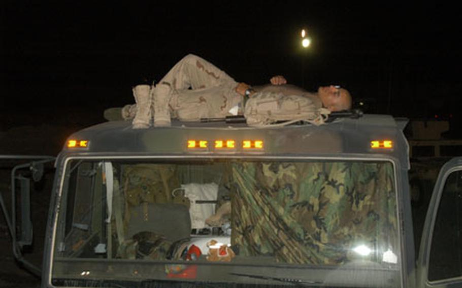 A soldier from 2nd Infantry Division’s 2nd Forward Support Battalion sleeps at Navistar, Kuwait, while waiting to head north into Iraq in this 2004 file photo.