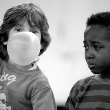 Seven-year-old Jimmie Buie blows a winning bubble while six-year-old Brandon Bell, seemingly preparing for the worst, watches.