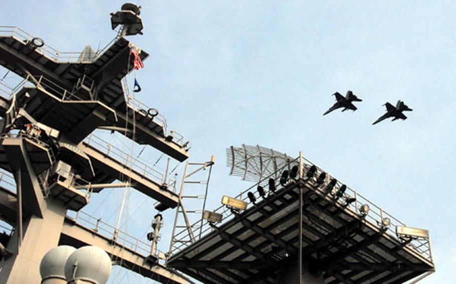 Two jets fly past the U.S.S. Nimitz Monday afternoon as they prepare to land on the ship’s flight deck.