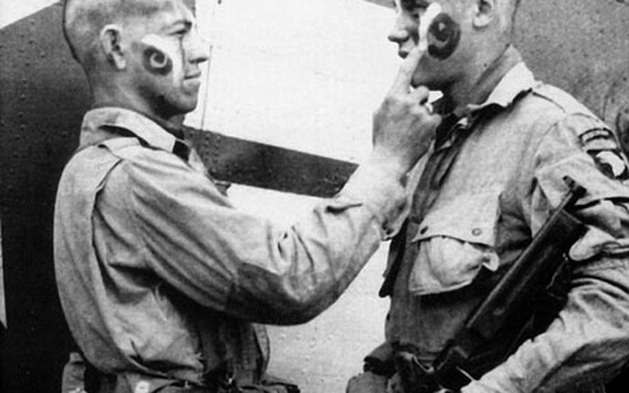 This photo of paratroopers Clarence C. Ware and Charles R. Plaudo painting each other&#39;s faces on the afternoon of June 5, 1944, was printed in Stars and Stripes, and helped form the legend of "The Filthy Thirteen."