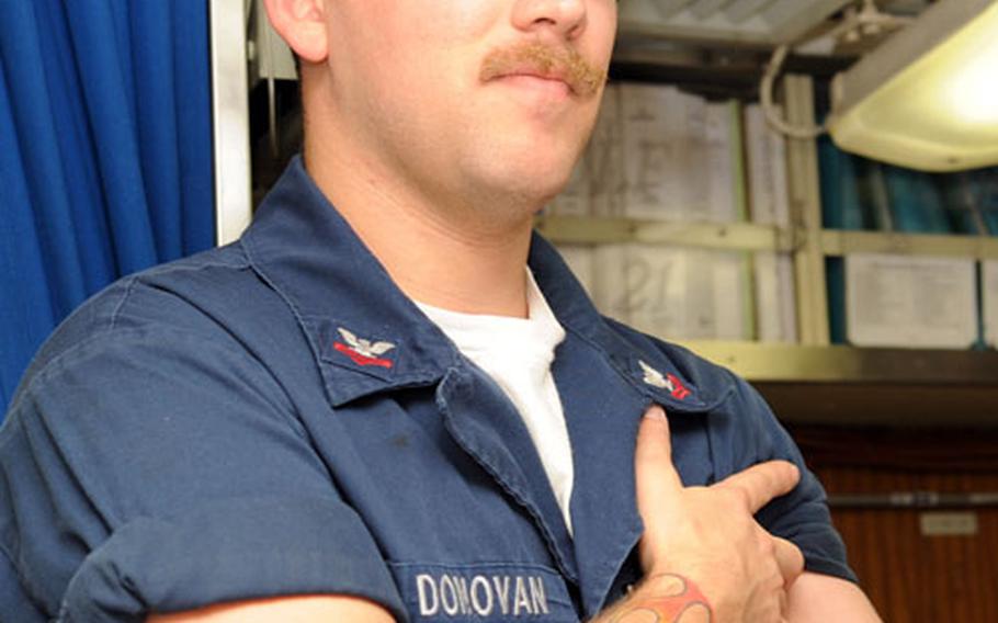 Petty Officer 2nd Class Tim Donovan displays the Dunkin’ Donuts on his left bicep. “It got me a free cup of coffee,” said Donovan, who helps maintain the USS Seawolf’s nuclear reactor.