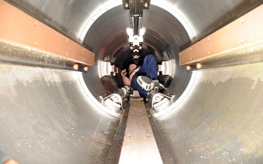 Petty Officer 3rd Class Levi Barr examines one of the USS Seawolf’s torpedo tubes. The tubes can accommodate MK-48 torpedoes and Tomahawk cruise missiles.