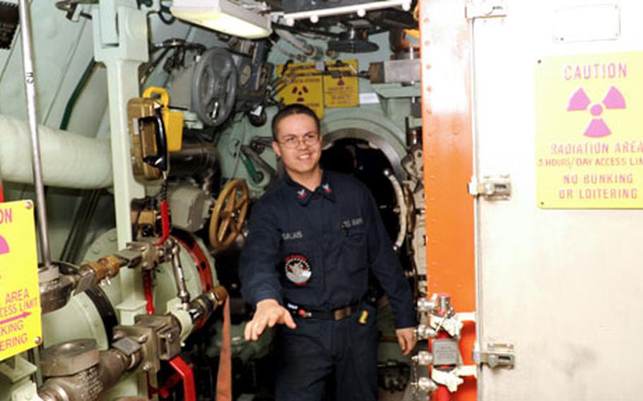 A sailor walks out of the aft part of the USS Seawolf, where the engine room and the nuclear reactor are located. The aft half of the boat is off-limits to most visitors.