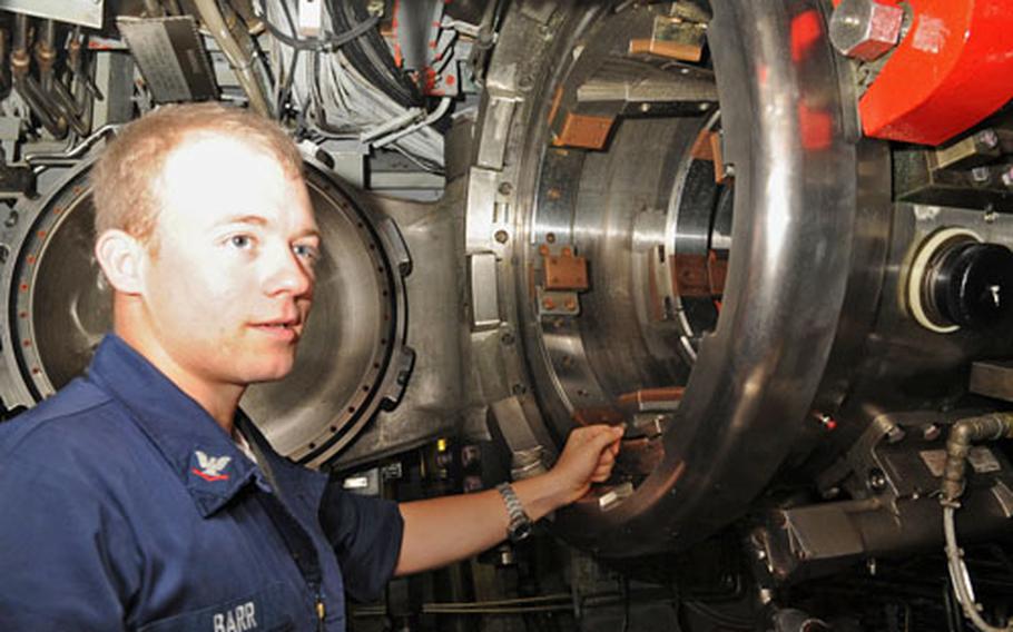 Petty Officer 3rd Class Levi Barr displays one of the USS Seawolf’s torpedo tubes. The tubes can accommodate MK-48 torpedoes and Tomahawk cruise missiles.