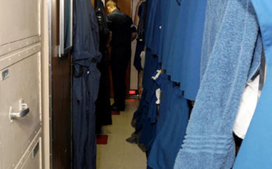 Sailors hang their towels over their curtains to get semi-dry in the 38-man berth, shown here. Bunk beds, or racks, are stacked in threes. The lights normally remain off, except during cleaning and during emergencies or drills.