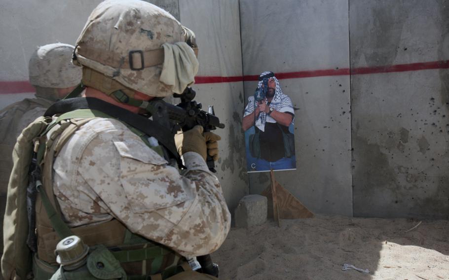 A U.S. Marine assigned to Company C, 1st Tank Battalion aims his M-4 carbine at a practice target during basic close-quarters combat training at the Marine Corps Air Ground Combat Center in California in April 2009.
In recent years, the military has trained troops to reinforce killing as a reflexive behavior. Bull's-eyes were replaced with targets that had human faces and bodies.