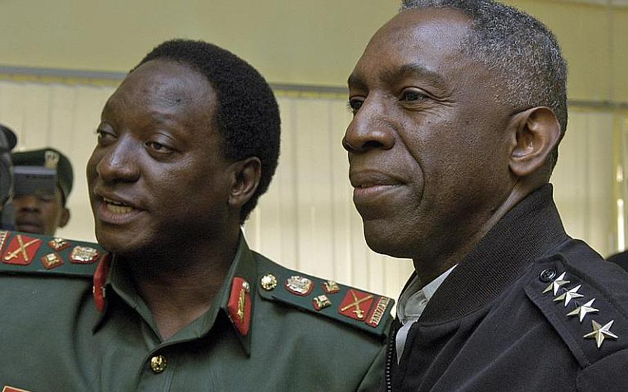 Tanzanian Gen. Davis Mwamunyange, left,  and U.S. Army Gen. William "Kip" Ward, commander of U.S. Africa Command, look at some Tanzanian military photos before holding formal meetings in Dar es Salaam, Tanzania, in 2009. Ward is leaving AFRICOM, and Gen. Carter Ham, the U.S. Army Europe commander, has been nominated to replace him.