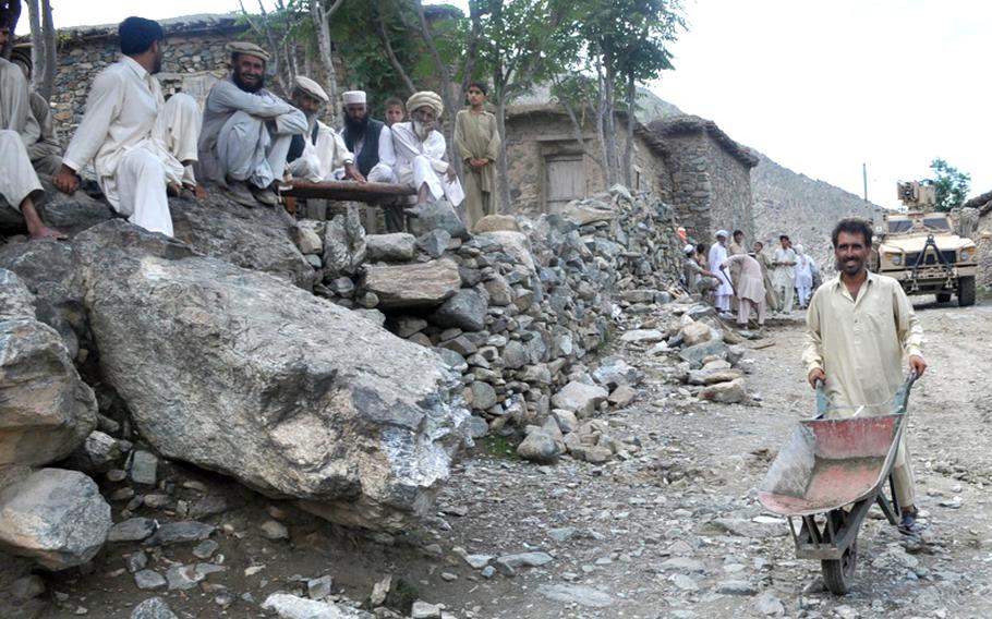 Sangam villagers watch workers repair Ghaki Valley Roadoad outside their village on Aug. 9. The U.S.-funded repairs followed a U.S.-led June offensive to rout insurgents from the valley.
