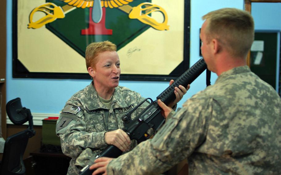 Spc. Wendy Rodriguez, who works at the Warrior Resiliency Campus on Camp Taji, Iraq, returns a weapon to a soldier after his visit to the campus on Friday.