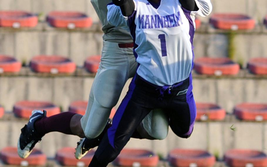 Baumholder's Ben McDaniels, left, and Mannheim defender LaJuarren Burks go up for a pass that neither pulled down in a Division II night game in Baumholder on Friday. Mannheim won the game, 36-0.