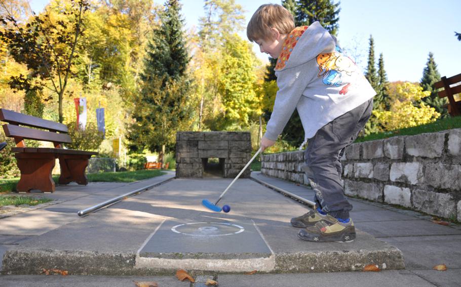 A young golfer takes a shot on the miniature golf course of Gössweinstein. The 18-hole golf course also has a Pit-Pat course, which is a mixture of mini-golf and billiards and played by people of all ages.